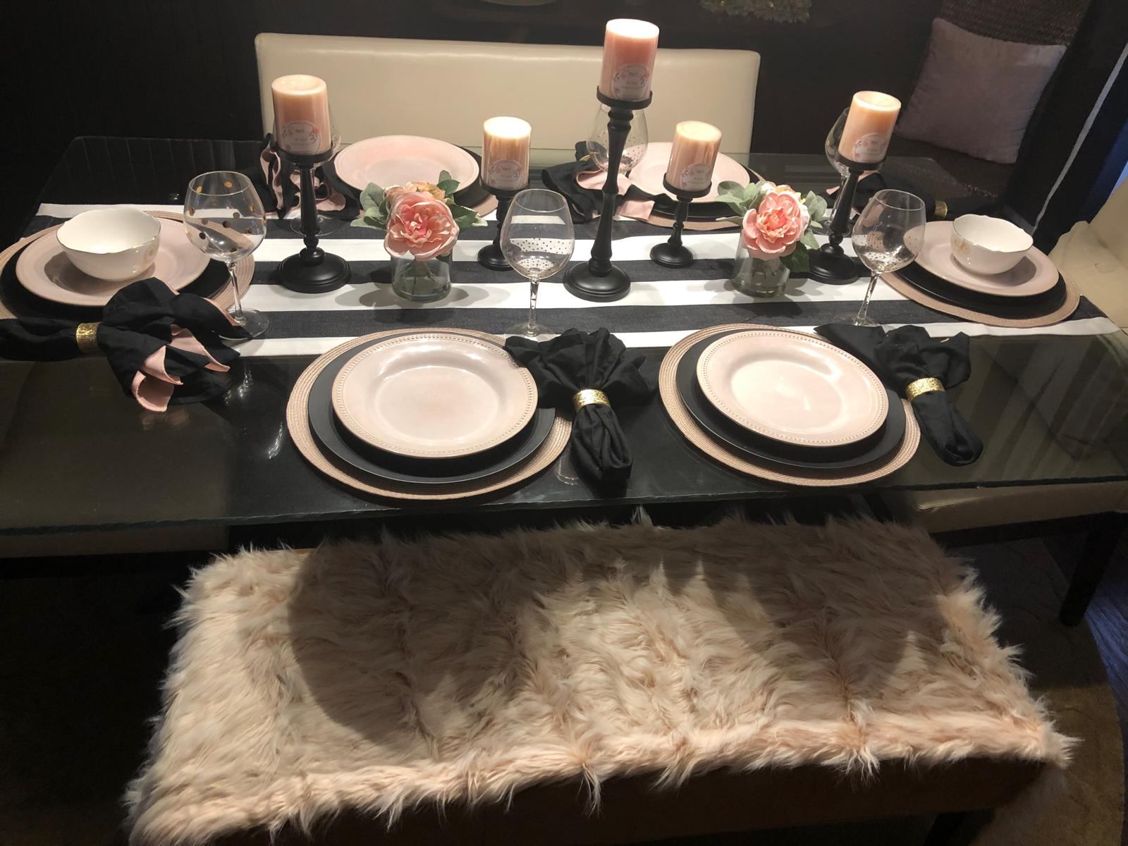 Wide view of a blush, black, and gold event table with a faux fur bench