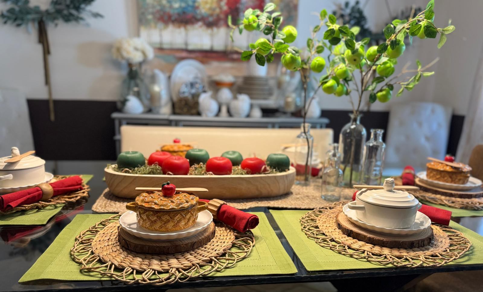 Fall dining table with red and green apple pillar candles in a wood tray