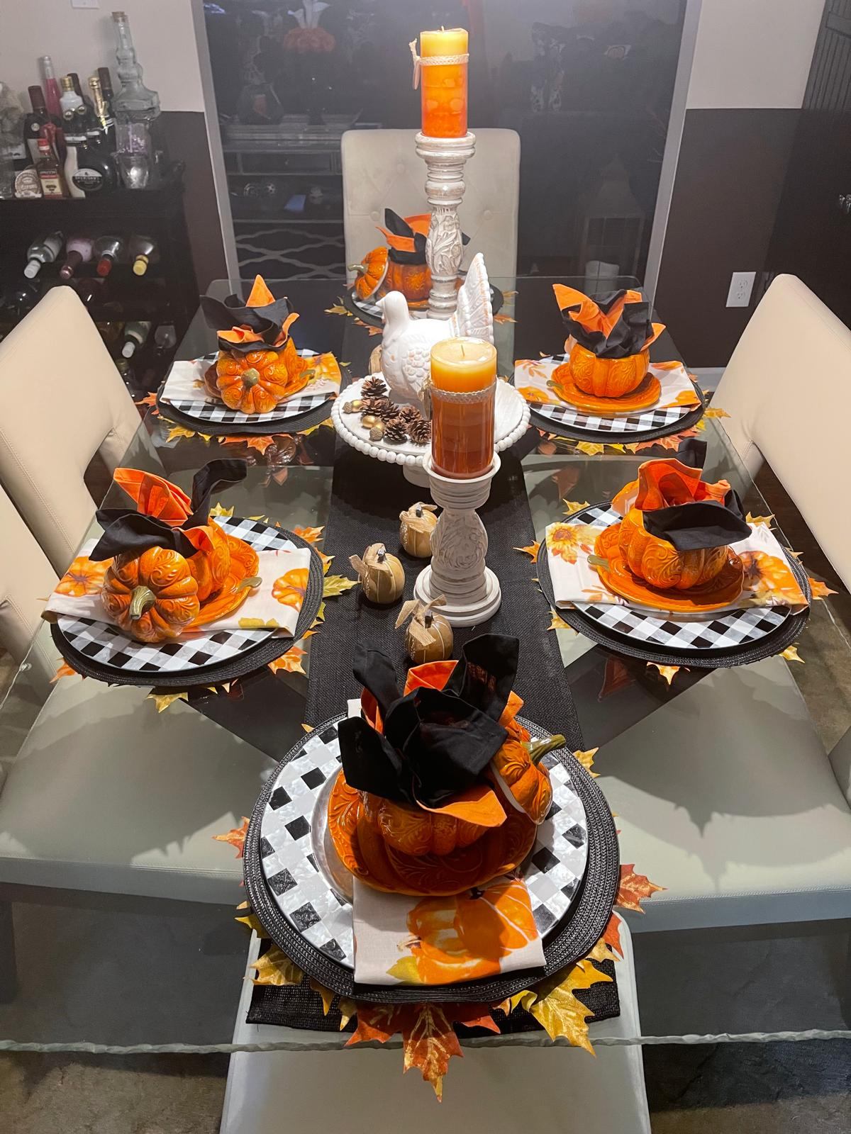 Thanksgiving table with pumpkin tureens, buffalo check plates, and a ceramic turkey centerpiece