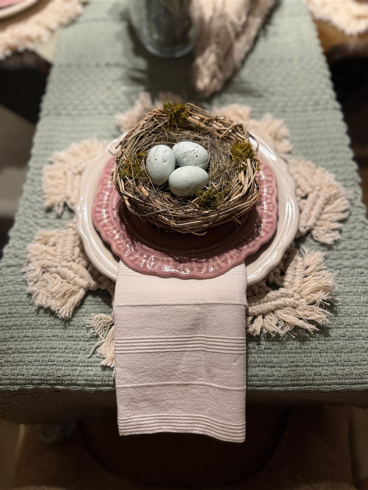 Place setting detail with a nest of speckled robin's eggs