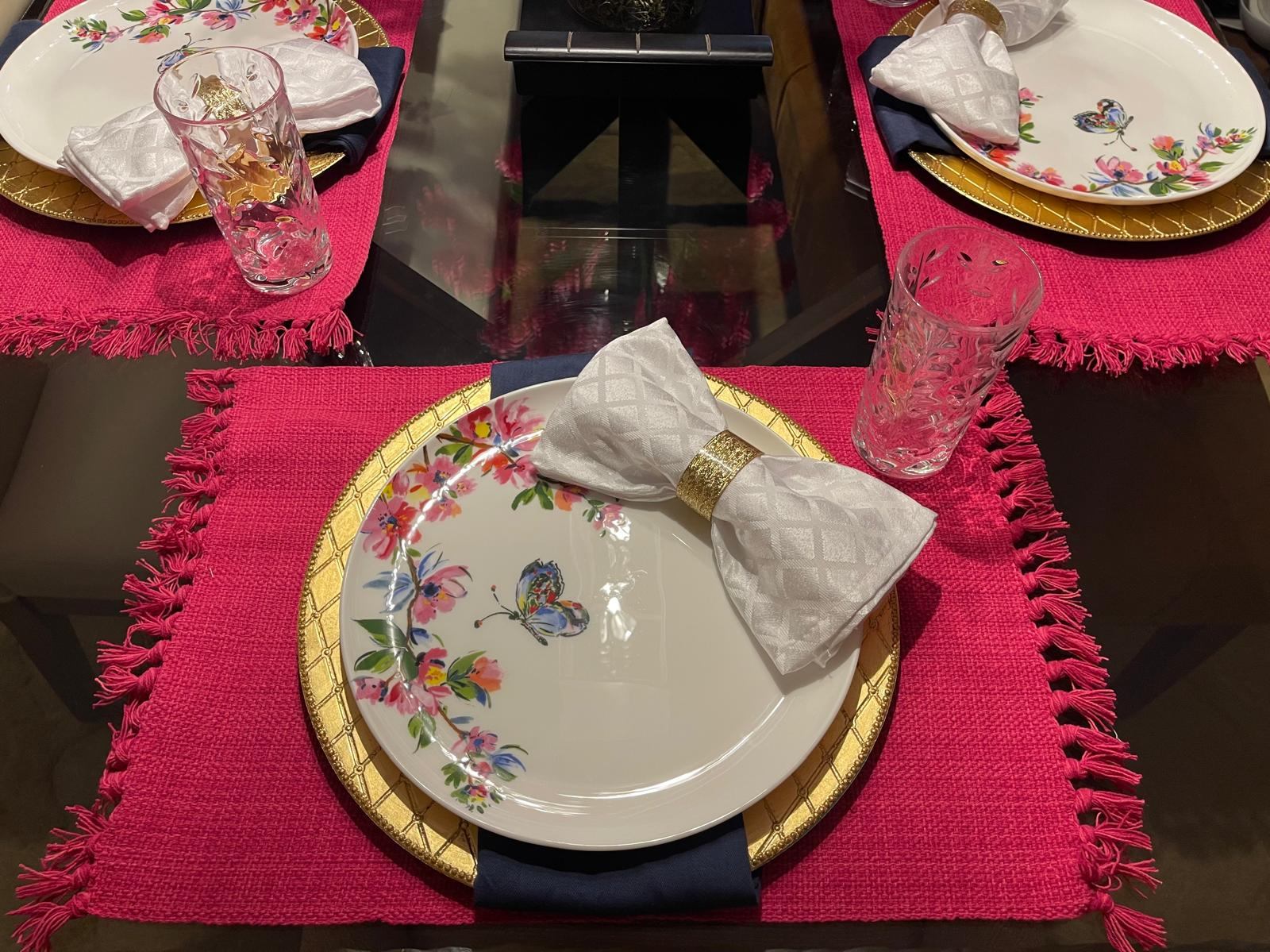 Place setting with a pink and gold butterfly floral plate and bow napkin