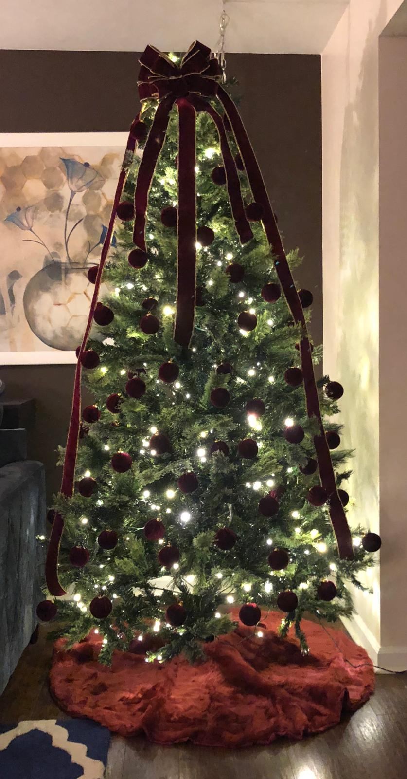 Christmas tree with burgundy velvet ornaments and a matching bow topper