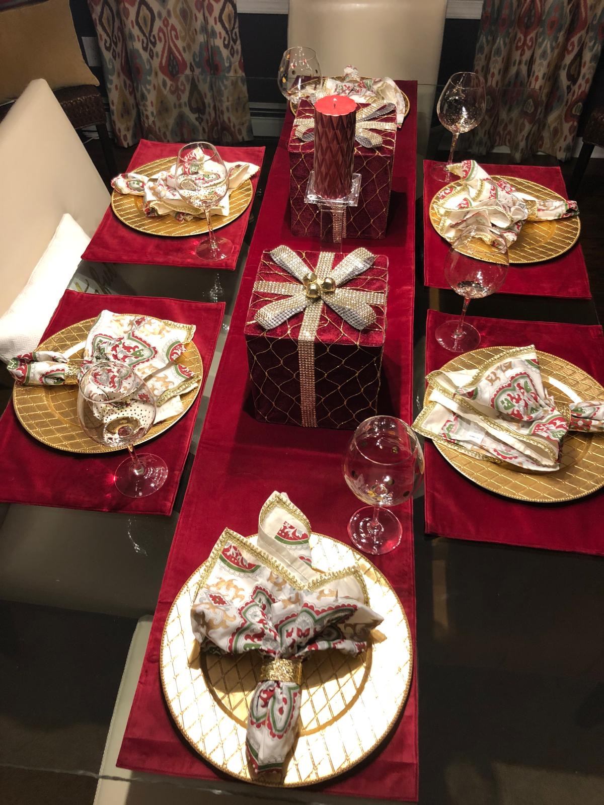 Elegant red and gold Christmas dinner table with velvet gift box centerpieces